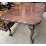 A mahogany extending dining table on cabriole legs and pad feet and casters