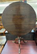 A 19th century oak tripod table with a circular top on a bird cage action,