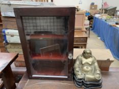 A bronze model of a seated buddha on a wooden base together with a wall mounted display cabinet