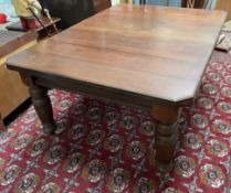 An Edwardian mahogany extending dining table on turned and reeded legs