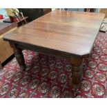 An Edwardian mahogany extending dining table on turned and reeded legs