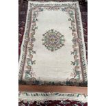 An Indian rug with a cream ground and floral decoration together with another Indian rug