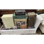 A wicker day bed together with loom laundry baskets, a side table,