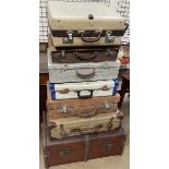A Rev Robe suitcase together with a collection of suitcases and a trunk