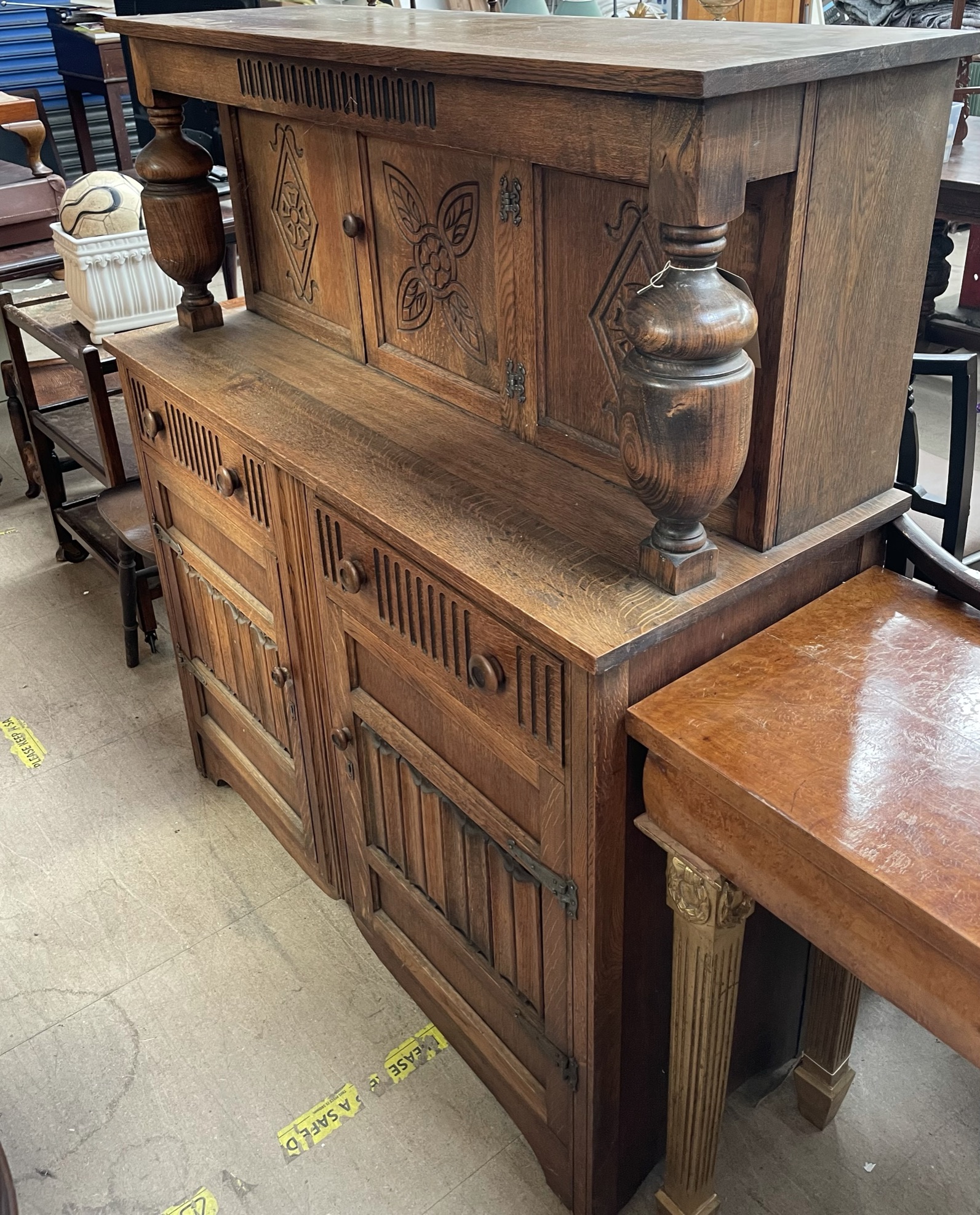 A 20th century oak court cupboard together with a tea trolley, two chairs,