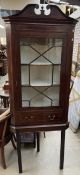 A 19th century mahogany hanging corner cupboard with a broken swan neck pediment,