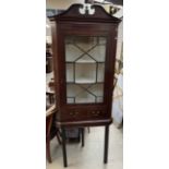 A 19th century mahogany hanging corner cupboard with a broken swan neck pediment,