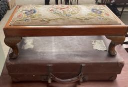 A footstool with embroidered top on cabriole legs together with a suitcase