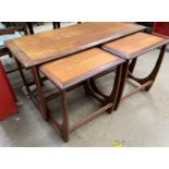 A mid 20th century teak nest of tables, with a crossbanded coffee table and two occasional tables,