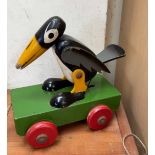 A wooden pull along toy of a black and white bird (possibly Disney's Dumbo related)