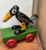 A wooden pull along toy of a black and white bird (possibly Disney's Dumbo related)