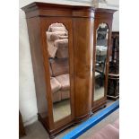 An Edwardian mahogany wardrobe, the moulded cornice above two mirrored doors on ball feet,