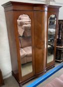 An Edwardian mahogany wardrobe, the moulded cornice above two mirrored doors on ball feet,