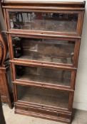 An oak four section bookcase with glazed doors, the base with a drawer on a plinth, 86.