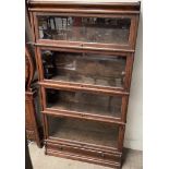 An oak four section bookcase with glazed doors, the base with a drawer on a plinth, 86.