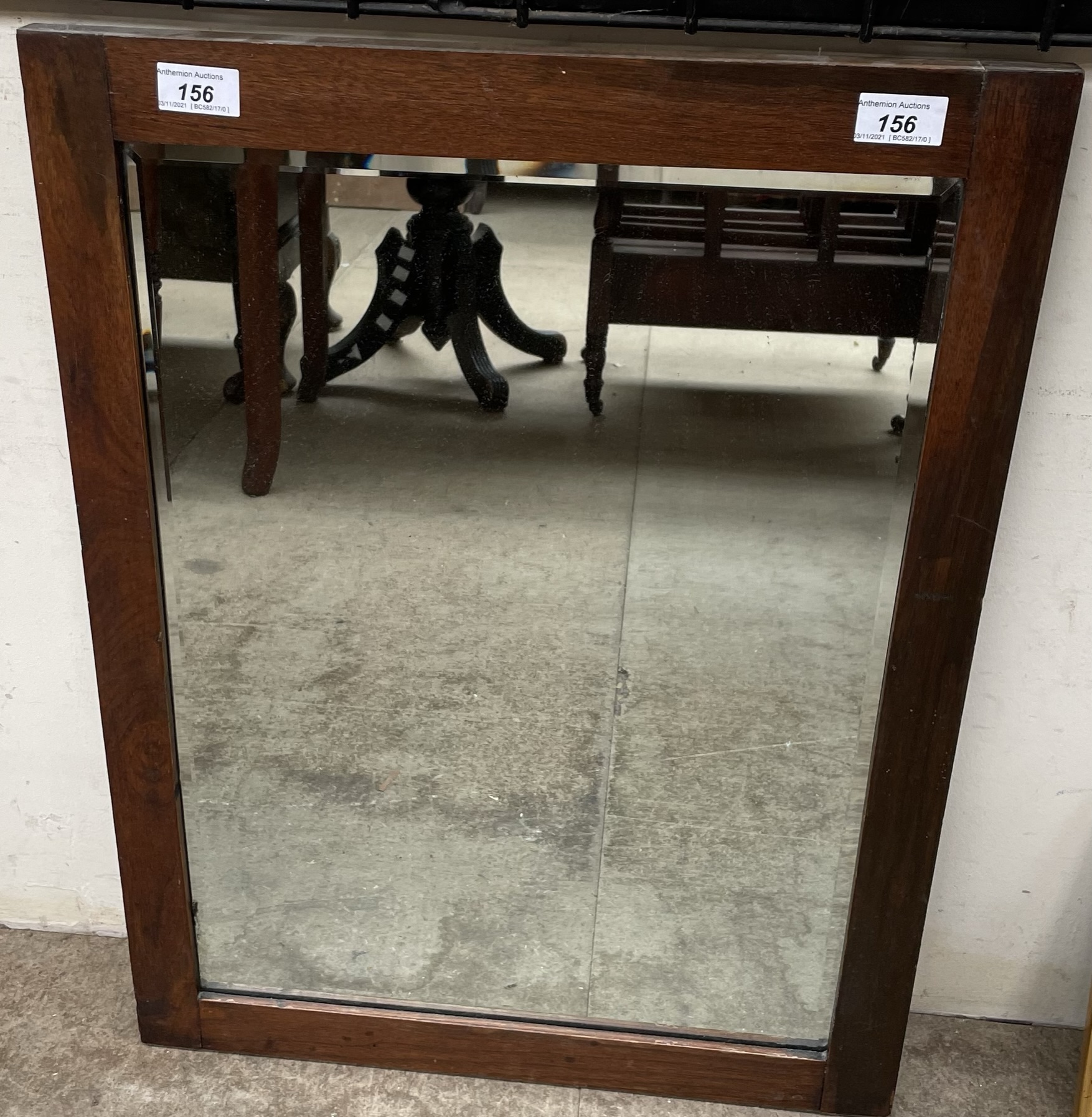 A rectangular framed wall mirror with a bevelled plate
