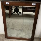 A rectangular framed wall mirror with a bevelled plate