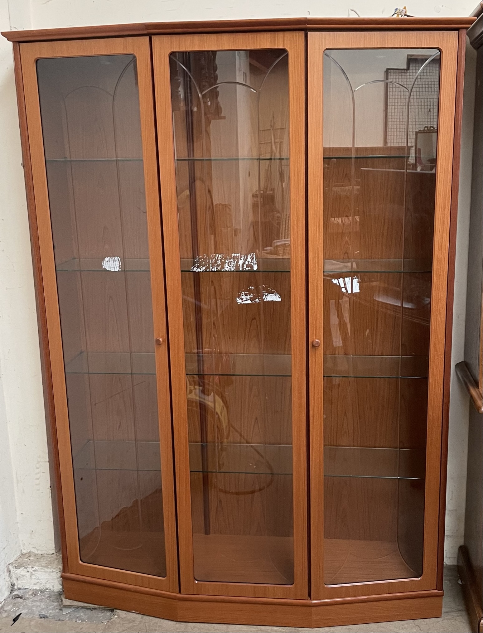 A modern teak effect three door display cabinet with glass shelves,