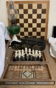 An oil lamp with green reservoir and cast metal base together with a chess board, horse brasses,