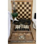 An oil lamp with green reservoir and cast metal base together with a chess board, horse brasses,