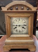 A Junghans walnut cased mantle clock, with a silvered dial and Roman numerals,