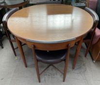 A G-Plan teak extending dining table of circular form with four chairs