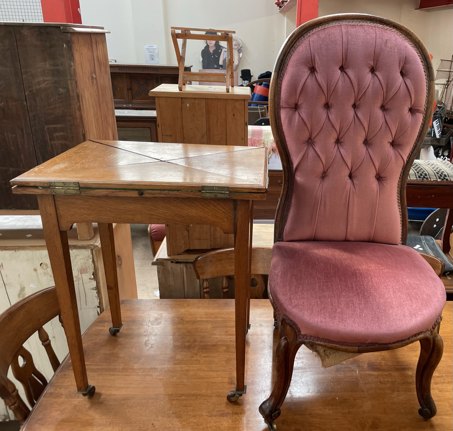 An Edwardian oak envelope card table together with a Victorian walnut framed spoonback nursing