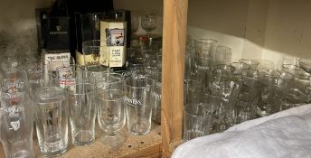 A large quantity of Guinness advertising pint glasses together with other advertising glasses