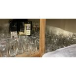 A large quantity of Guinness advertising pint glasses together with other advertising glasses