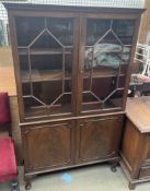 A 20th century mahogany display cabinet with a moulded cornice above a pair of glazed doors,