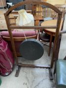 A gong suspended between an oak frame