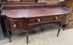 A 19th century mahogany sideboard, with a raised back above a shaped top,