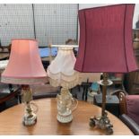 A gilt metal table lamp on three lions paw feet together with an onyx table lamp and a cherub table