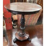 A Victorian and later mahogany wine table with a circular top above a leaf carved column and