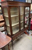 An Edwardian mahogany display cabinet, with a moulded cornice above a pair of glazed doors,