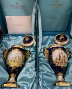 A pair of limited edition Coalport porcelain lidded rams head vases one painted with a view of