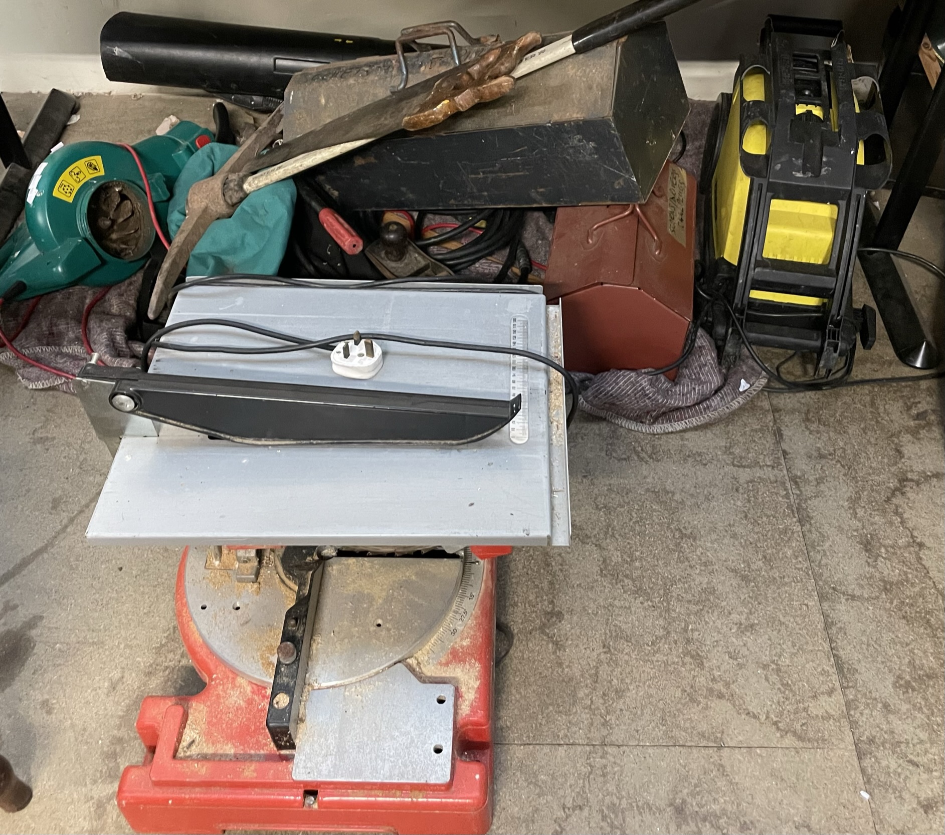 A collection of tools, table top saw,