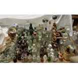 Assorted glass bottles together with stoneware bottles, glass decanters,
