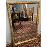 A gilt framed wall mirror decorated with leaves