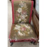 A Victorian nursing chair with a tapestry back and seat on ring turned legs and casters