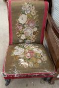 A Victorian nursing chair with a tapestry back and seat on ring turned legs and casters