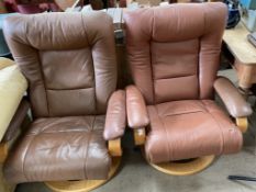 A pair of brown leather elbow chairs