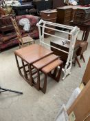 A teak nest of three square topped tables together with a white painted towel rail