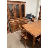 A modern dining table together with six chairs and a matching wall unit