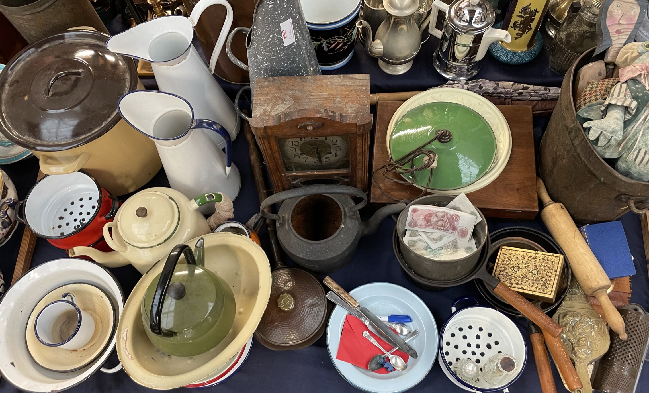 Enamel jugs, together with storage bins, teapot, clock, saucepans,