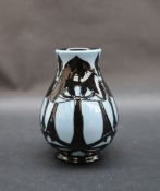 A Moorcroft pottery vase decorated with trees silhouetted against a light blue ground,