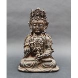 A bronze Buddhistic seated figure, with right hand raised, left hand holding a flame,