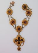 A Victorian yellow metal necklace, of scrolling and bead form, set with cabochon garnets, diamonds,