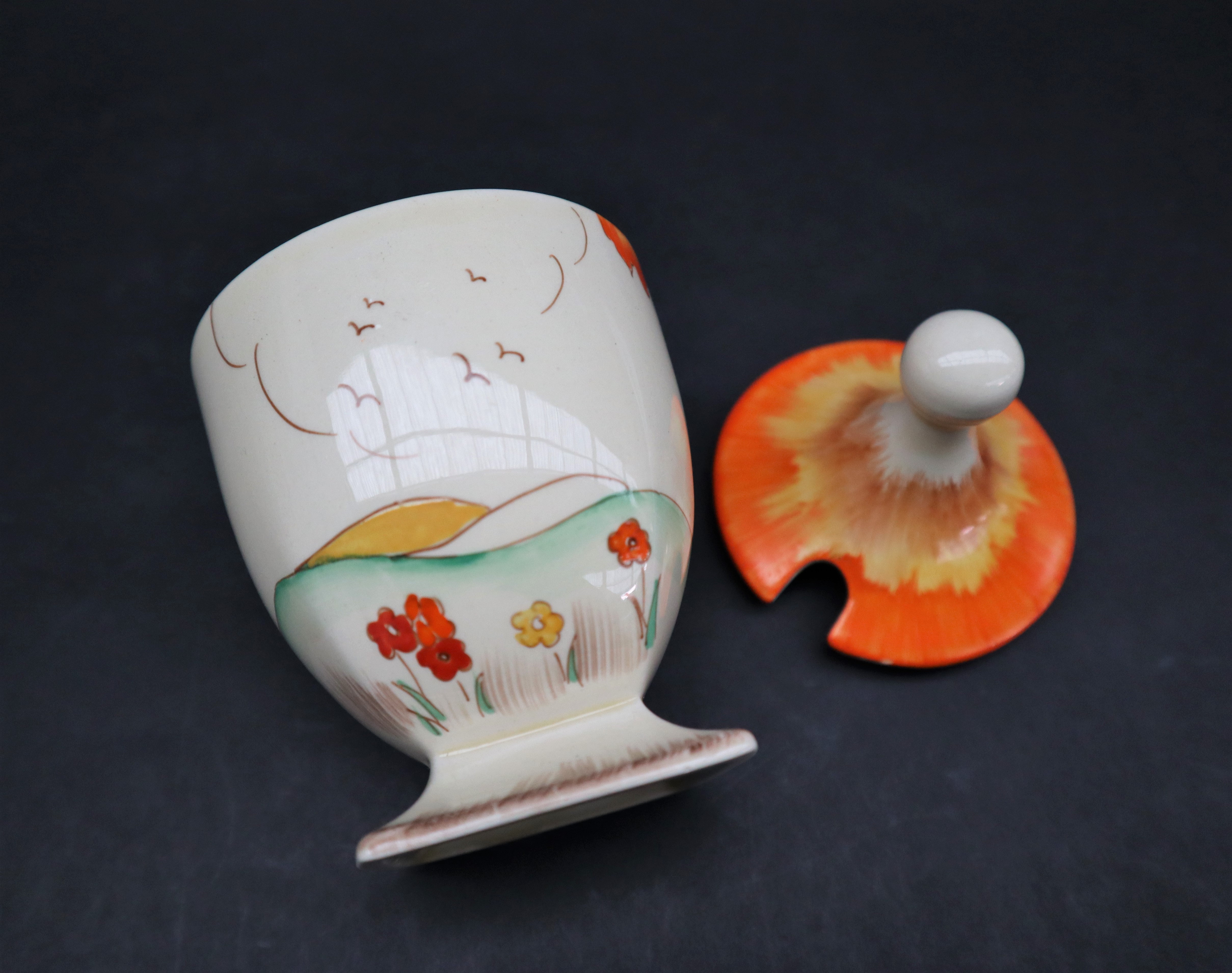 A Clarice Cliff preserve pot and cover, painted with an orange tree and coastal landscape beyond, - Image 3 of 5