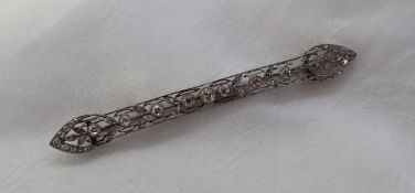 A Victorian diamond bar brooch, set with round old cut diamonds to a white metal wirework setting,